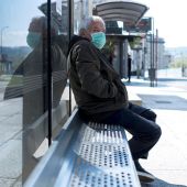 Un hombre con una mascarilla en una parada de autobús en Ourense.