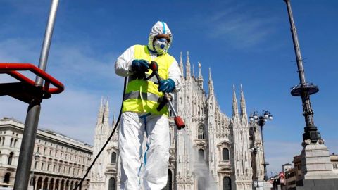 Imagen de una persona limpiando las calles en Italia con una mascarilla