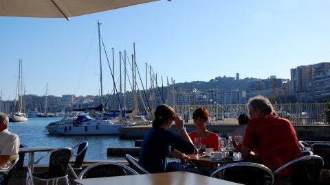 Gente disfrutando de una terraza frente al mar, en el Paseo Mar&iacute;timo de Palma.
