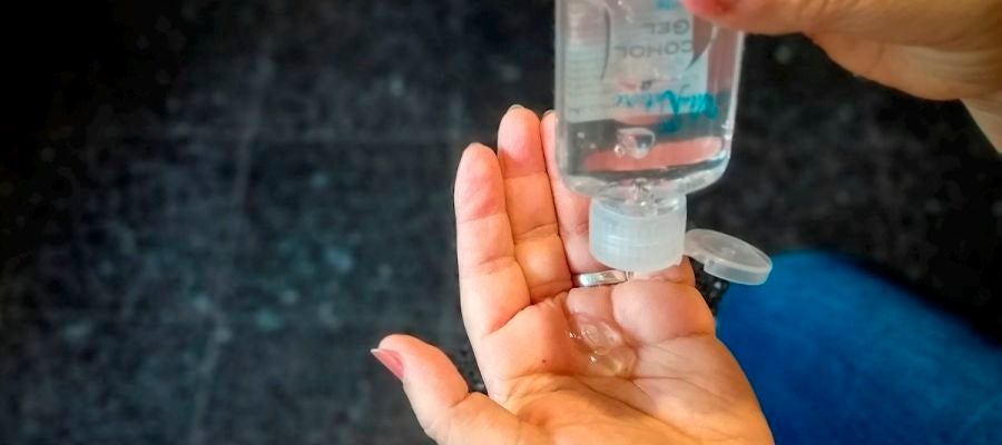Imagen de una mujer echándose en las manos un gel hidroalcóholico Imagen de una mujer echándose en las manos un gel hidroalcóholico