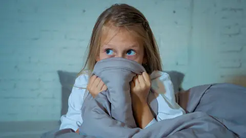 Una niña con miedo en la cama Una niña con miedo en la cama