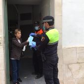 Un agente de la Policía Local de Crevillent entrega una mascarilla a una vecina de la localidad.