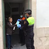 Un agente de la Policía Local de Crevillent entrega una mascarilla a una vecina de la localidad. Un agente de la Policía Local de Crevillent entrega una mascarilla a una vecina de la localidad.
