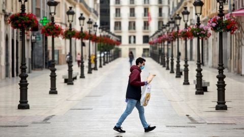 Una persona camina por la calle Larios, en M&aacute;laga