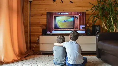 Niños frente al televisor Niños frente al televisor