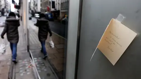 Una tarjeta de pésame en la fachada de un comercio Una tarjeta de pésame en la fachada de un comercio