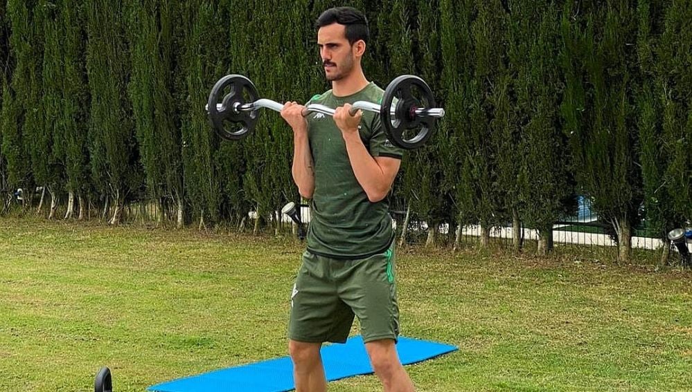 Juanmi, jugador del Betis, levanta pesas en su domicilio.