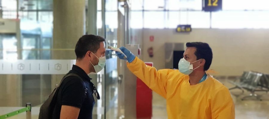 Toma de temperatura a un viajero en un aeropuerto. Toma de temperatura a un viajero en un aeropuerto.