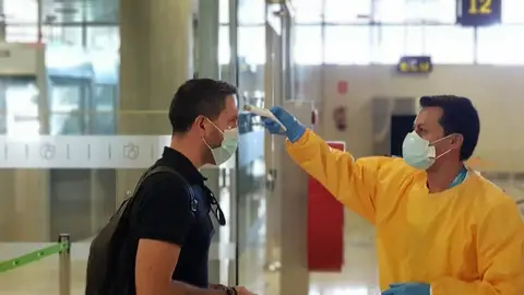 Toma de temperatura a un viajero en un aeropuerto. Toma de temperatura a un viajero en un aeropuerto.