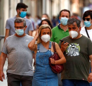 Ciudadanos pasean por la calle protegidos con mascarillas Ciudadanos pasean por la calle protegidos con mascarillas