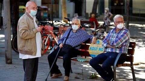 Tres hombres con mascarilla para evitar la propagación del covid-19.