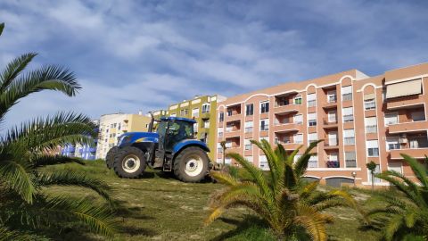 Un tractor realizando labores de mantenimiento en un solar de Aspe.