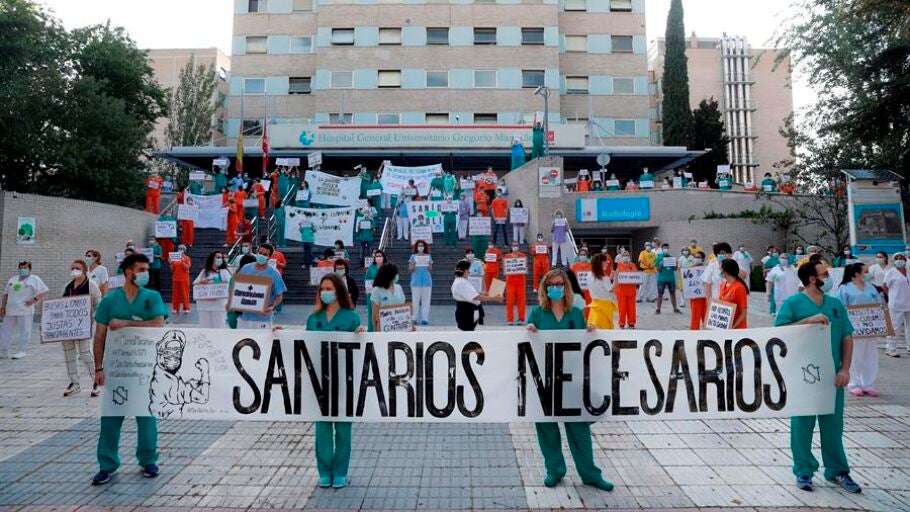 Sanitarios del Hospital Gregorio Mara&ntilde;&oacute;n posan con una pancarta en la que se lee "Sanitarios necesarios"