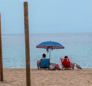 Una pareja disfruta del buen tiempo en la playa de Palmanova de Calviá, Mallorca Una pareja disfruta del buen tiempo en la playa de Palmanova de Calviá, Mallorca