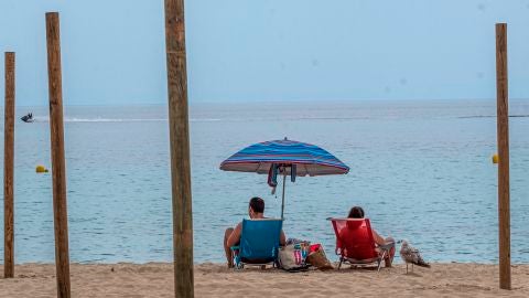 Una pareja disfruta del buen tiempo en la playa de Palmanova de Calvi&aacute;, Mallorca