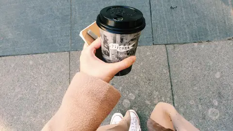 Una mujer con un café para llevar Una mujer con un café para llevar