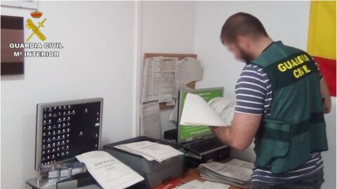 Agente de la Guardia Civil examina documentaci&oacute;n.