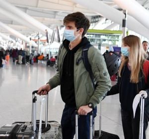 Pasajeros con mascarilla en un aeropuerto Pasajeros con mascarilla en un aeropuerto
