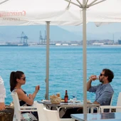 Un camarero con mascarilla pasa ante una pareja que almuerza en un restaurante de Málaga Un camarero con mascarilla pasa ante una pareja que almuerza en un restaurante de Málaga