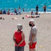 Personas con mascarilla en una playa