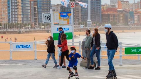 Un grupo de personas pasean por el paseo mar&iacute;timo de la playa de San Lorenzo de Gij&oacute;n .