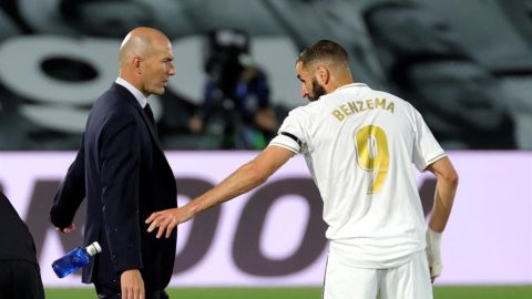 Zidane y Benzema charlan en la banda durante un partido del Real Madrid.