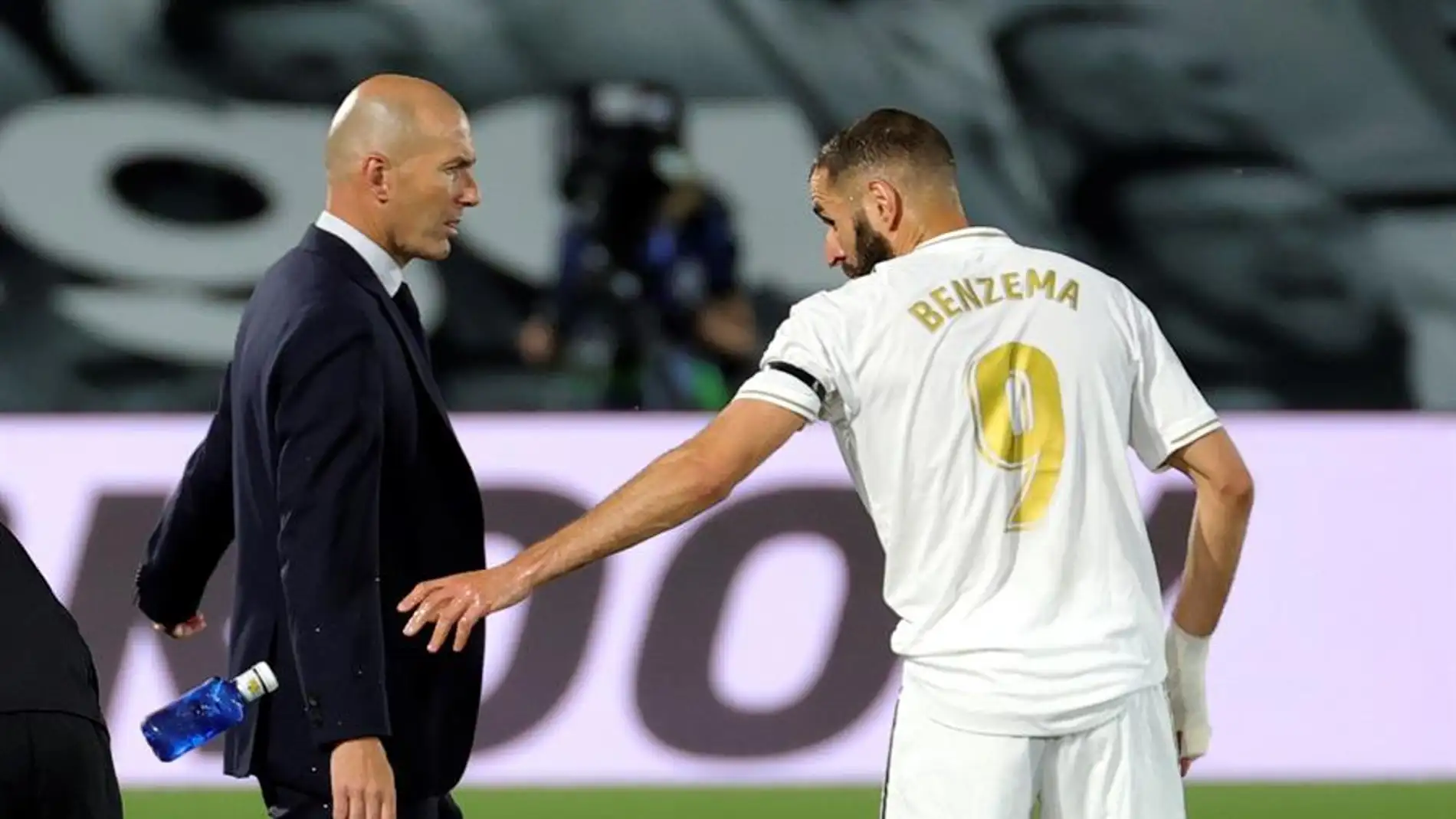 Zidane y Benzema charlan en la banda durante un partido del Real Madrid.