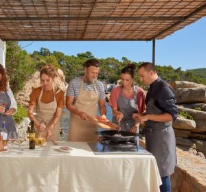 Pla general d'un grup de persones fent un tast de vins i cuinant un plat durant una excursió enogastronòmica pels camins de ronda de la Costa Brava Pla general d'un grup de persones fent un tast de vins i cuinant un plat durant una excursió enogastronòmica pels camins de ronda de la Costa Brava