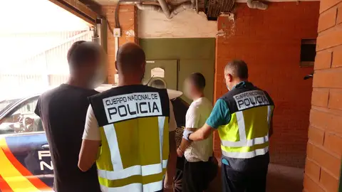 Agentes de la Policía Nacional con dos de los detenidos en Elche. Agentes de la Policía Nacional con dos de los detenidos en Elche.