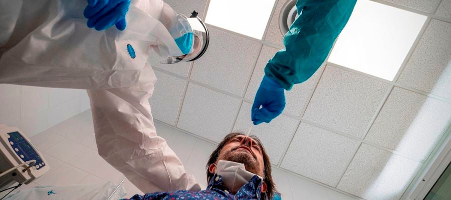 Dos médicos realizan una prueba de coronavirus a un paciente Dos médicos realizan una prueba de coronavirus a un paciente