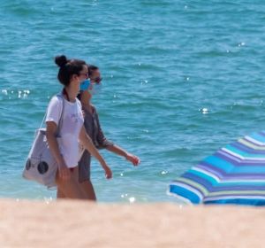 Dos jóvenes con mascarilla en una playa de Andalucía Dos jóvenes con mascarilla en una playa de Andalucía