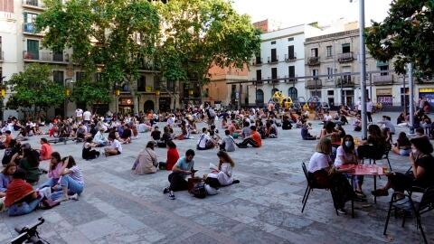 Multitud de j&oacute;venes toman cervezas en la plaza del Sol del barrio de Gracia de Barcelona