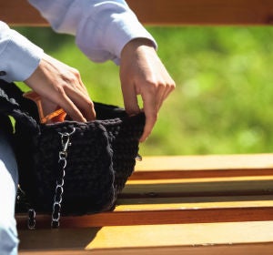 Una mujer revisa su bolso Una mujer revisa su bolso