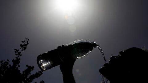 Un hombre se refresca de las alta temperaturas.