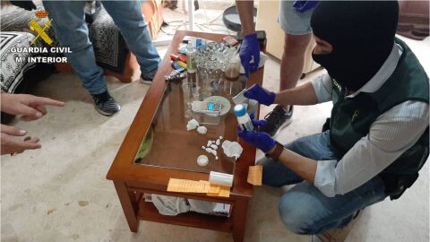 Los agentes hacen recuento del material incautado en el domicilio del sospechoso.