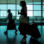 Viajeros con mascarillas caminan por el aeropuerto de El Prat (Archivo)