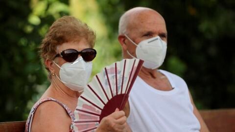 Varias personas descansan en la zona de Madrid R&iacute;o, en la capital con mascarilla 