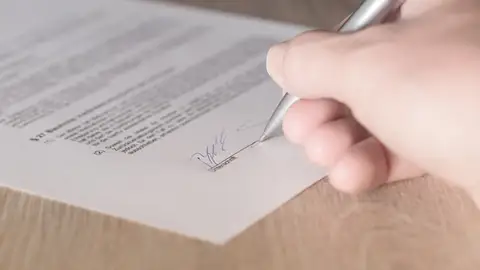 Una persona durante la firma de un contrato de trabajo. Una persona durante la firma de un contrato de trabajo.