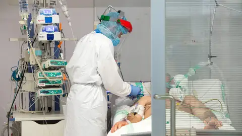 Un sanitario atiende a un paciente de COVID Un sanitario atiende a un paciente de COVID
