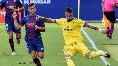 El defensa de la SD Huesca Pablo Maffeo (izda) pelea por el control del bal&oacute;n con el delantero del C&aacute;diz CF, &Aacute;lvaro Negredo