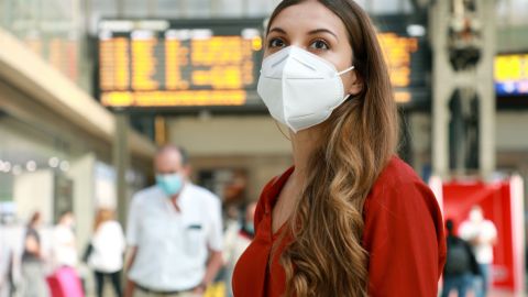 mujer con mascarilla en una estación