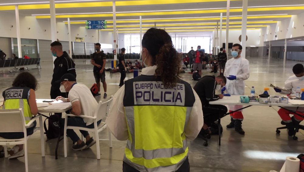 Agentes de la Policía Nacional atienden a migrantes llegados a las costas de Baleares.