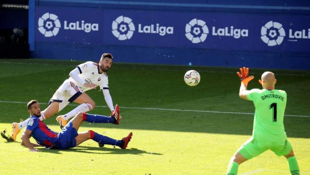 El delantero del Osasuna Enric Gallego (c) remata ante el jugador de la SD Eibar Burgos, y el guardameta Dimitrovic El delantero del Osasuna Enric Gallego (c) remata ante el jugador de la SD Eibar Burgos, y el guardameta Dimitrovic