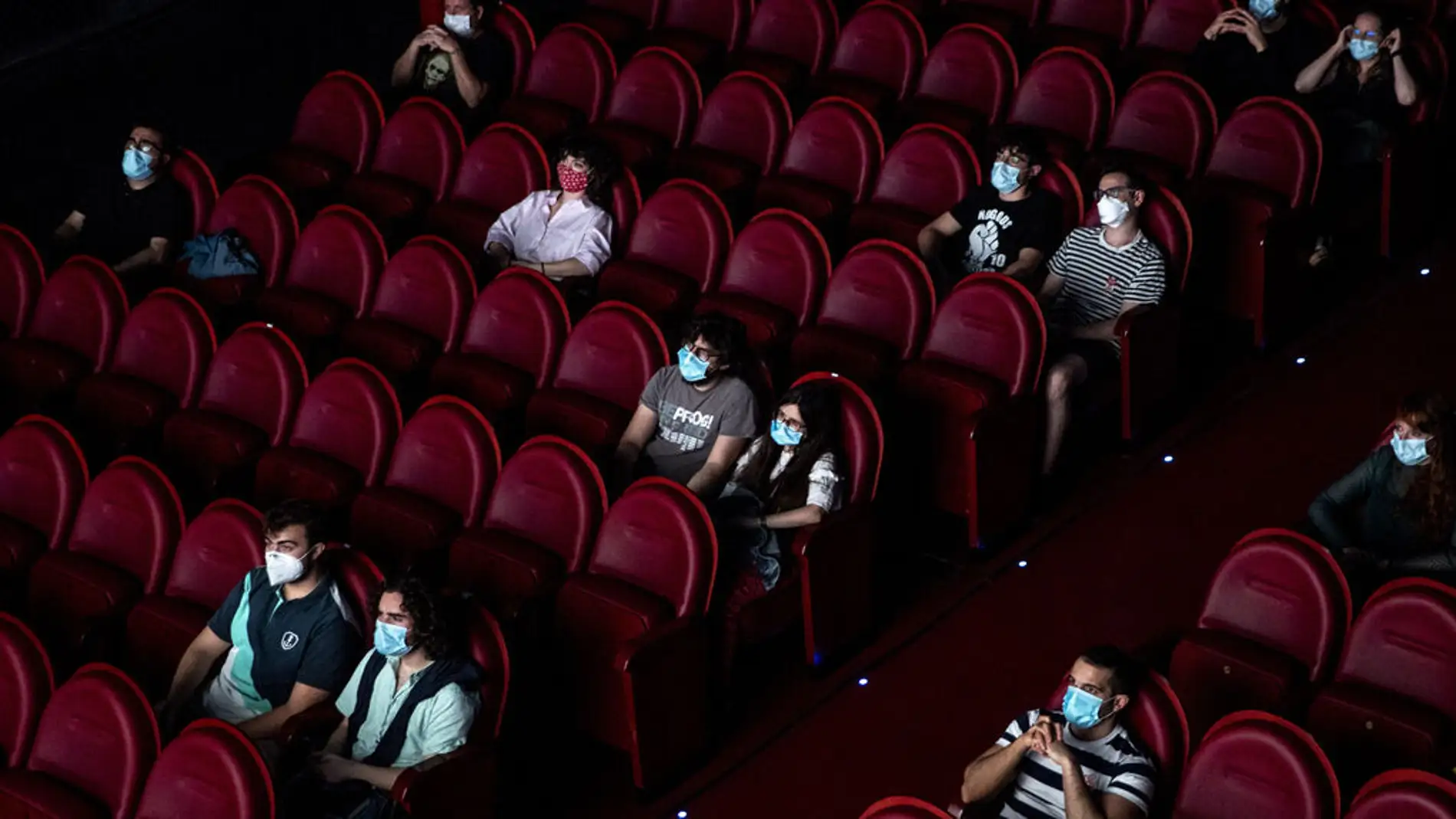 Espectadores en una sala de cine, distanciados y con mascarilla