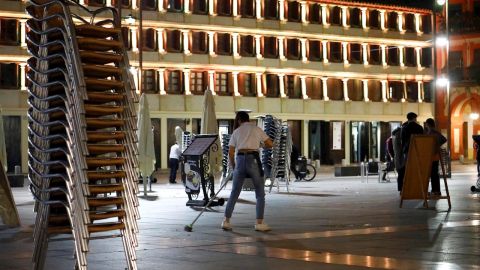 Un camarero recogiendo la terraza de su bar en C&oacute;rdoba el domingo