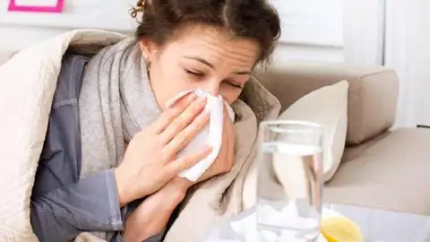 Persona con un pañuelo debido a la gripe Persona con un pañuelo debido a la gripe