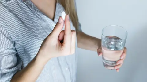 Una persona toma un medicamento Una persona toma un medicamento