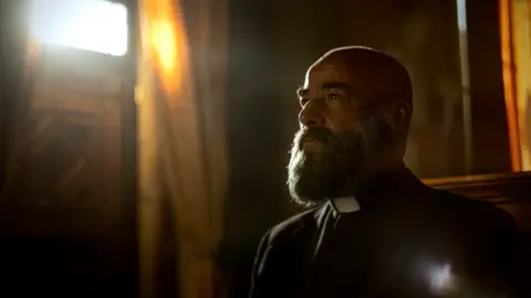 El actor Eduard Fernández, caracterizado como el padre Manuel Vergara en la serie '30 monedas' SERIES