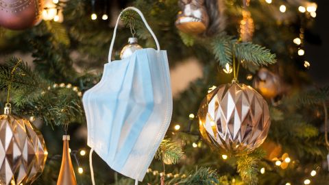 Una mascarilla colgada de un &aacute;rbol de Navidad