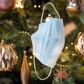Una mascarilla colgada de un árbol de Navidad Una mascarilla colgada de un árbol de Navidad
